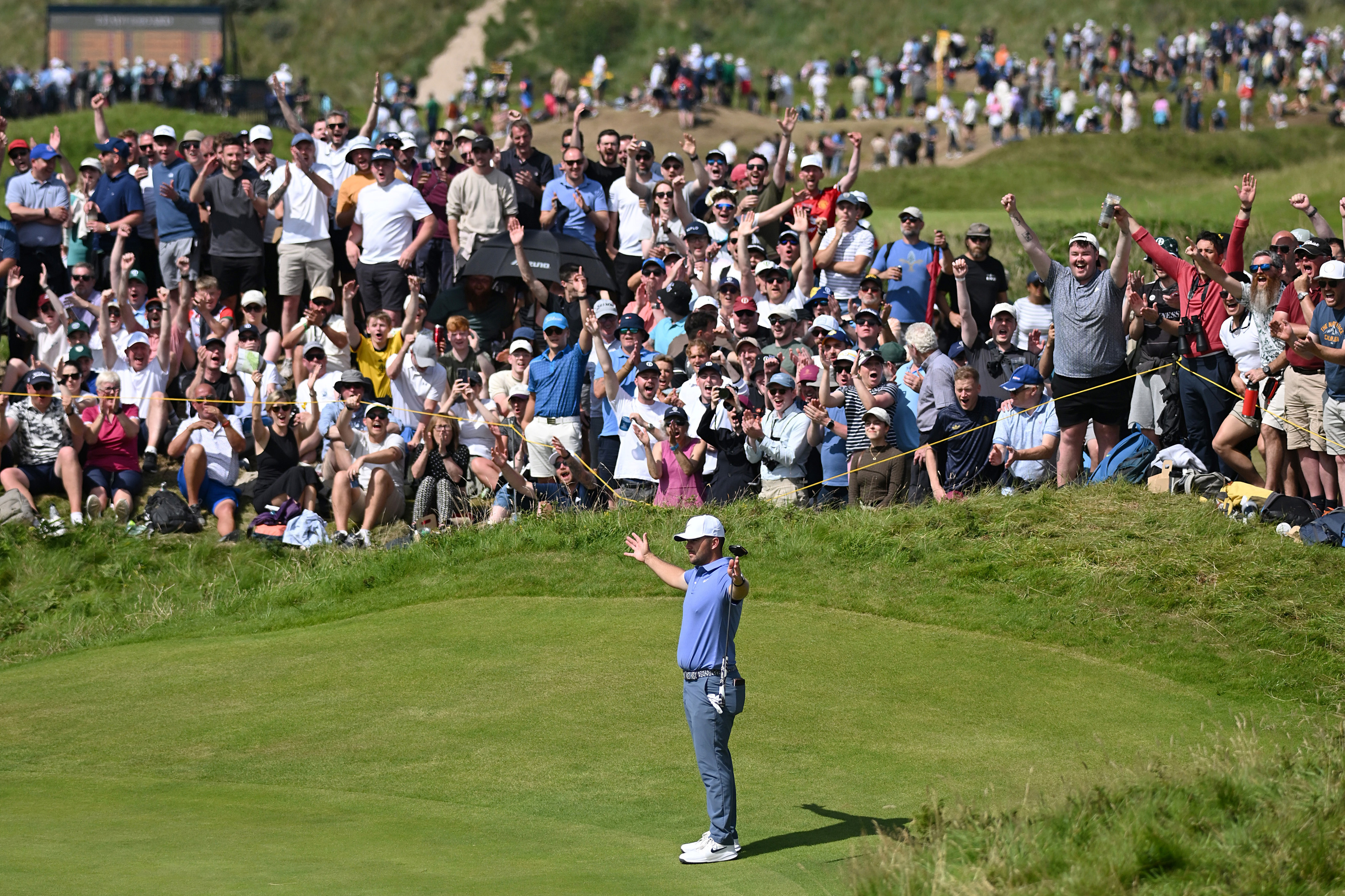 Chris Gotterup stands with his arms aloft during round four of The Open at Royal Portrush