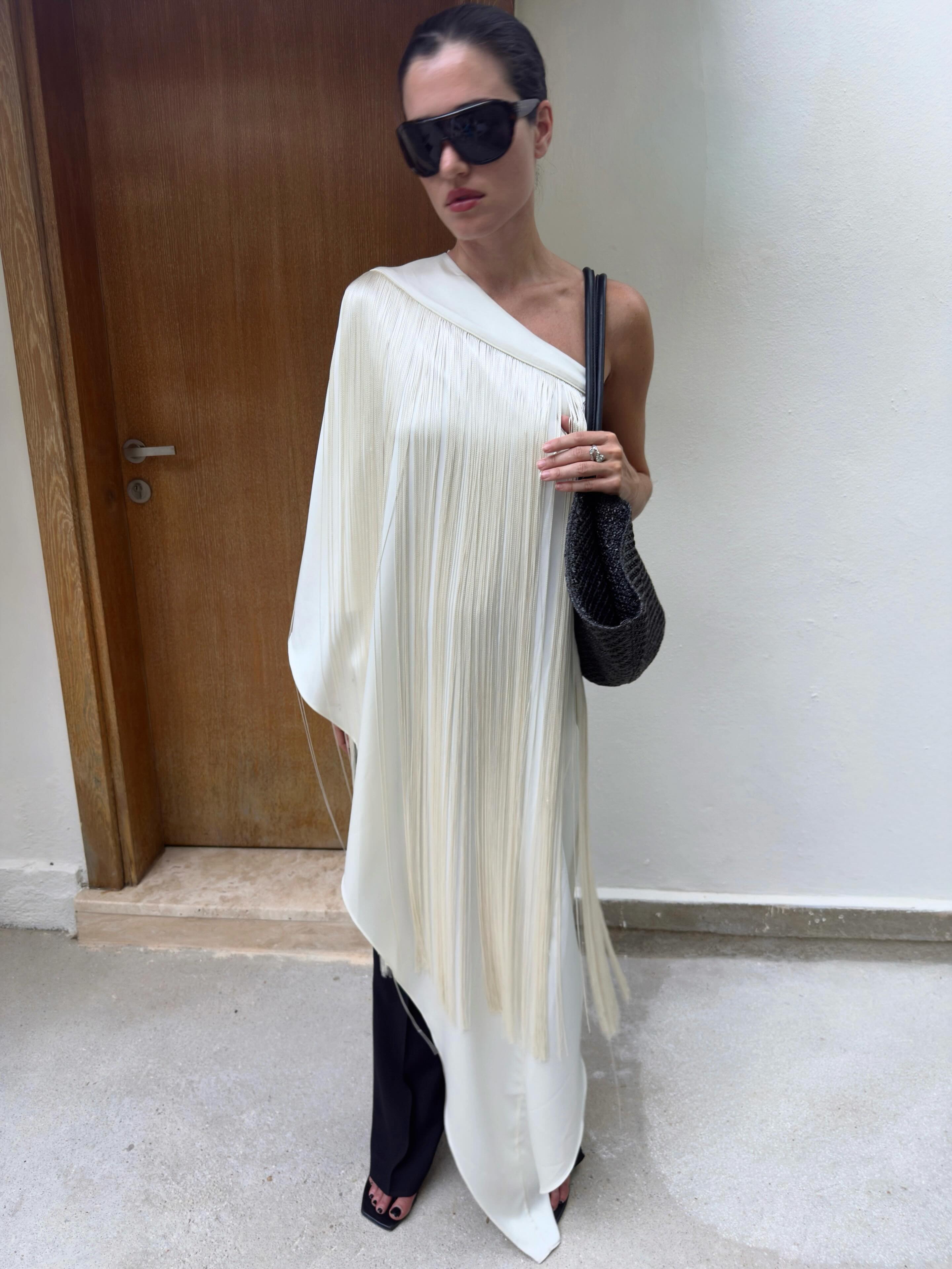 Influencer @iliridakrasniqi wears shield sunglasses with a white long-line blouse.
