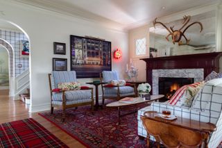 Living room with red patterned rug, tartan rug, armchairs, sofa, coffee table and side table