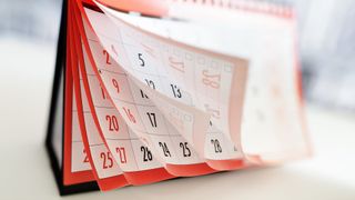 monthly calendar set up on a tabletop with its pages turning