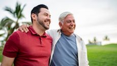 Father and adult son talking while walking on public park