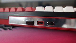 The Gamakay TK101 gaming keyboard in a red and white colourway and on a colourful mouse pad.