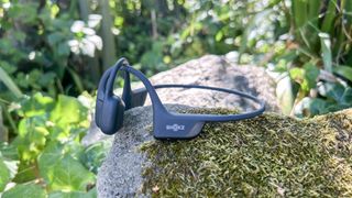 Shokz OpenRun Pro 2 headphones on a mossy stone outside