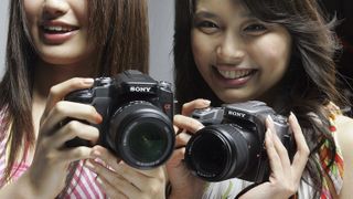 TOKYO, JAPAN - JUNE 6: Models show off Sony's digital single-lens reflex (DSLF) camera Alpha "DSLR-A100" during a press conference on June 6, 2006 in Tokyo, Japan. This is Sony's first DSLF 10.2-megapixel with a 21 lens camera which will be released on July 21, 2006. (Photo by Junko Kimura/Getty Images)