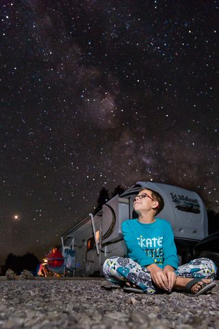 Benjamin Oostdyk patiently waits for early Perseid meteors while camping with his family in Idaho in this photo taken by his mother Catherine a few days before the peak of the Perseid meteor shower of 2018. Mars is visible as the bright orange object at left.