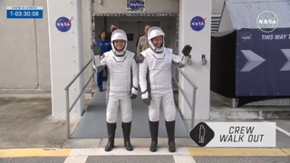 Crew-9 astronauts in white and black spacesuits wave as they head to their launch pad.