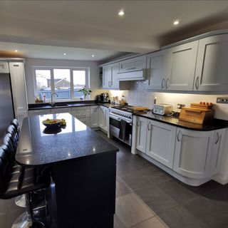 white kitchen with laminated white cabinets and black worktop