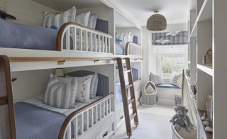 boys bedroom with four bunk beds and blue and white color scheme