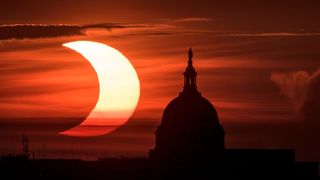 The eclipsed sun rises over the U.S. Capitol Building on June 10, 2021, in an image from NASA photographer Bill Ingalls.