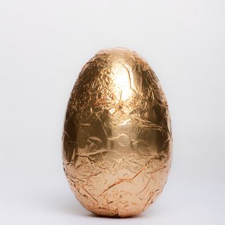A chocolate Easter egg wrapped in gold foil.