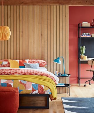 colorful bedroom with wooden panelling and yellow bedsheets