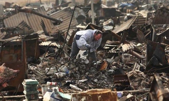 A man searches through the remains of his home on Dec. 4 in Breezy Point, Queens, N.Y.