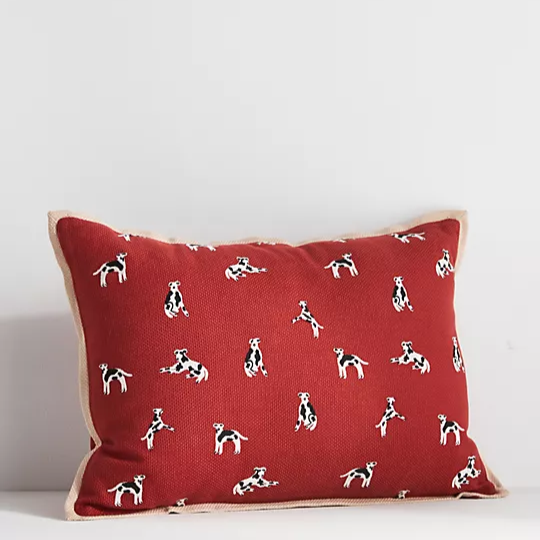 orange pillow covered with dogs