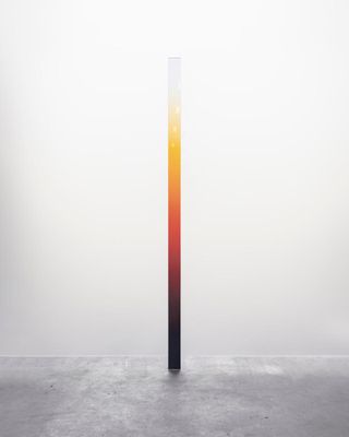 Tall glass mirrored beam by Germans Ermics, featuring colour gradient including black, red, yellow and white