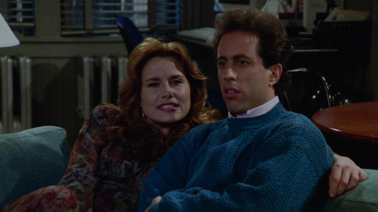 Jennifer Coolidge with Jerry Seinfeld sitting on a counch on Seinfeld