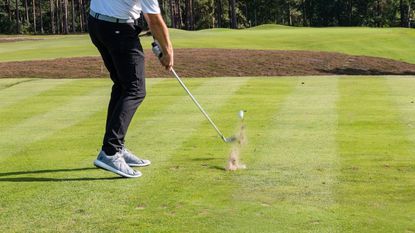 A golfer hitting an iron shot into a par-3