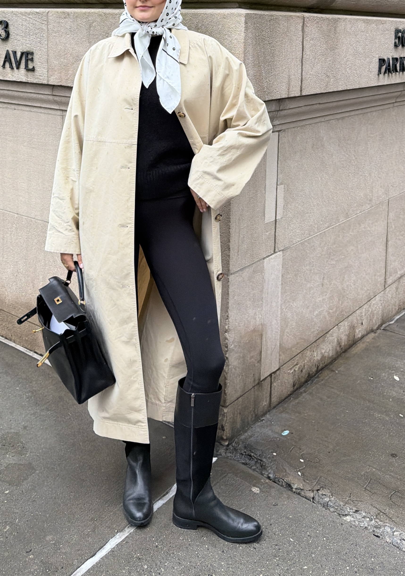 Sara Walker in a trench, leggings, and boots.