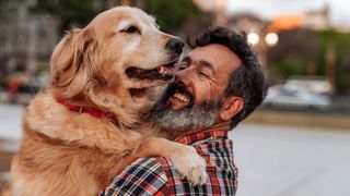 Man hugging his Golden Retriever dog outside