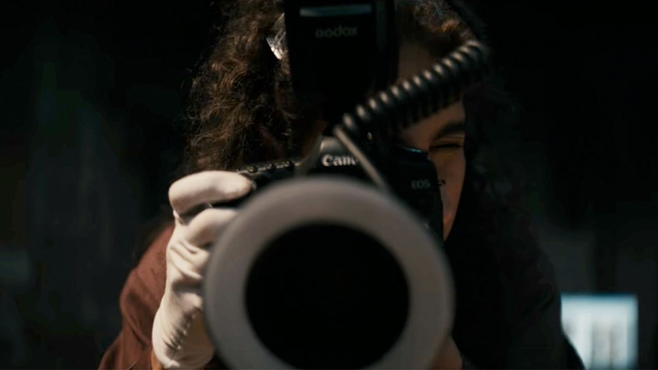 A woman looking into a camera that is pointed right at the camera in Lee Cronin's The Mummy.