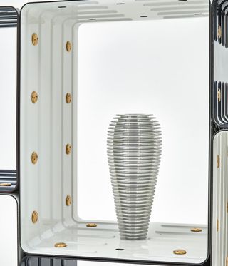 White shelves with a silver vase in it