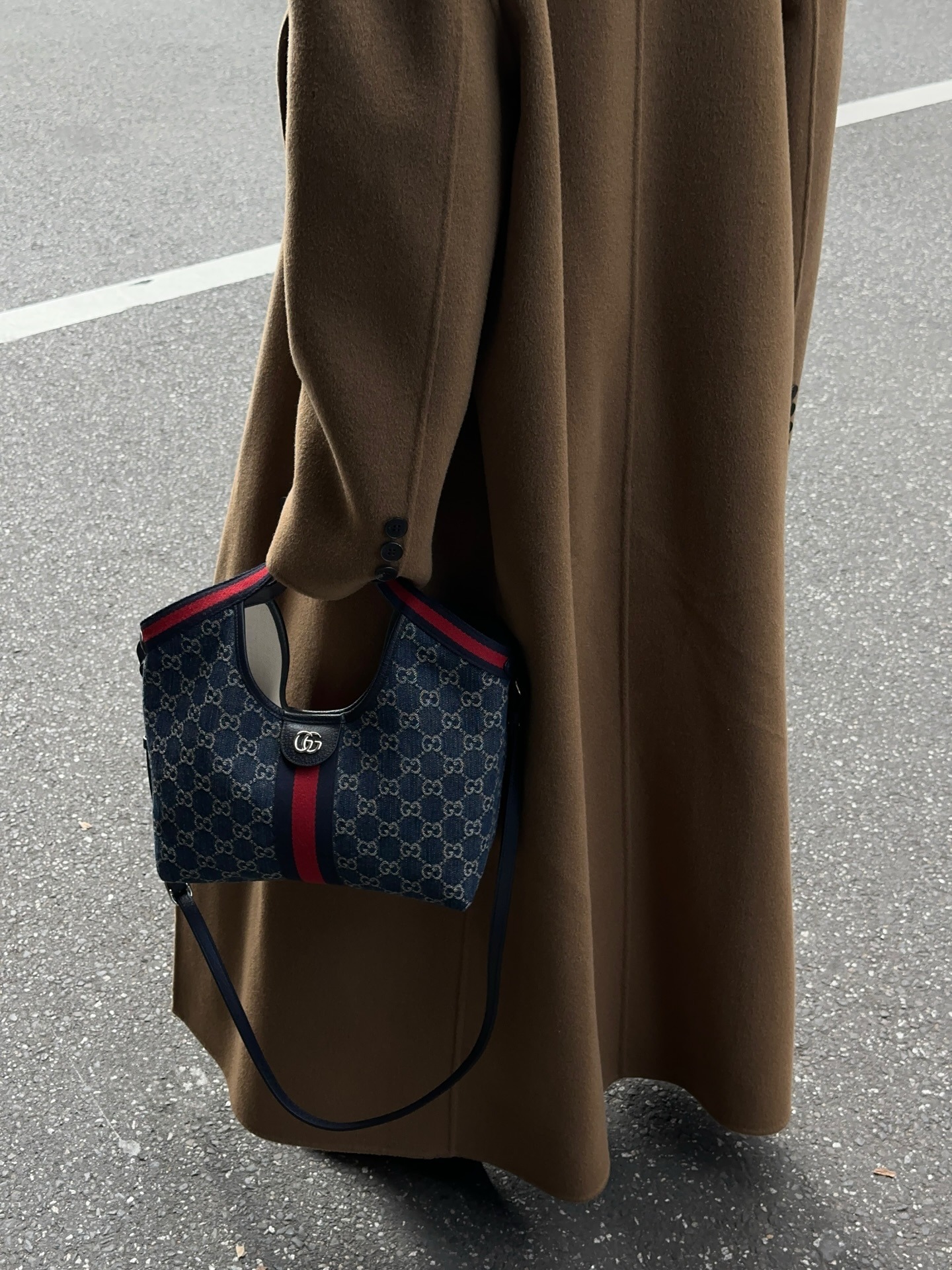 Woman wears white vest, sheer skirt and carries Gucci Giglio bag