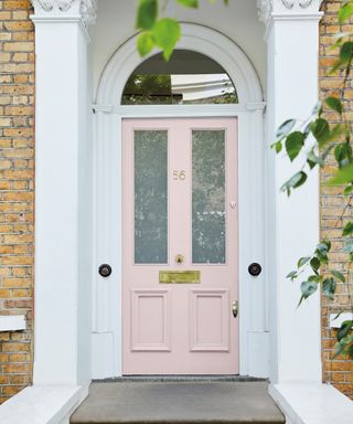 A small front porch with a pale pink front door