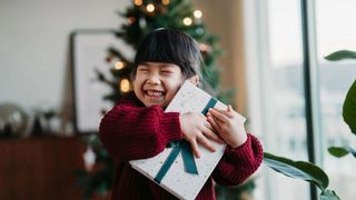 girl hugging a christmas present