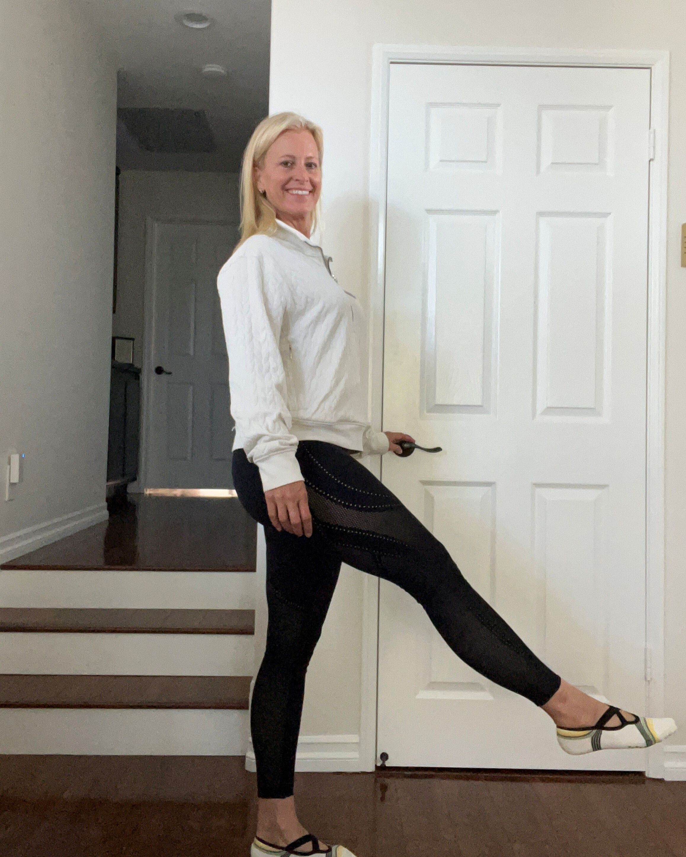 Woman standing on one leg with her raised foot in front of her