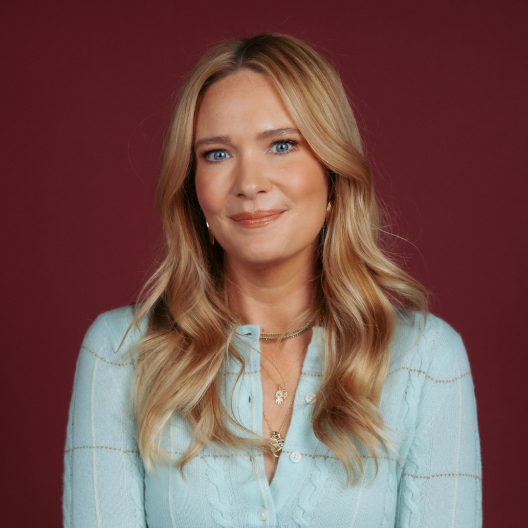 sarah j maas smiles wearing a blue sweater in a promo shot for her appearance on call her daddy