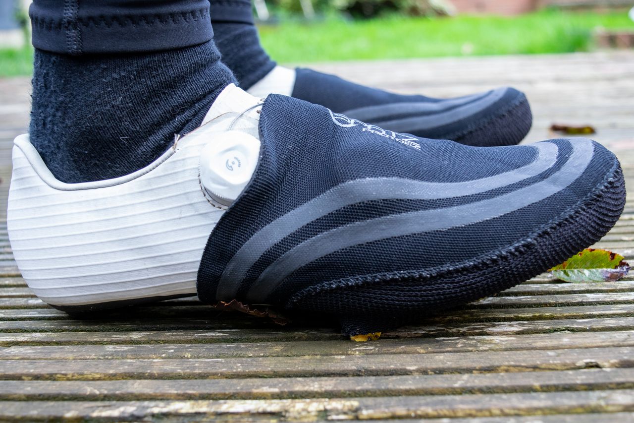A cyclist wearing Spatz Pro Toez toe covers on wooden decking