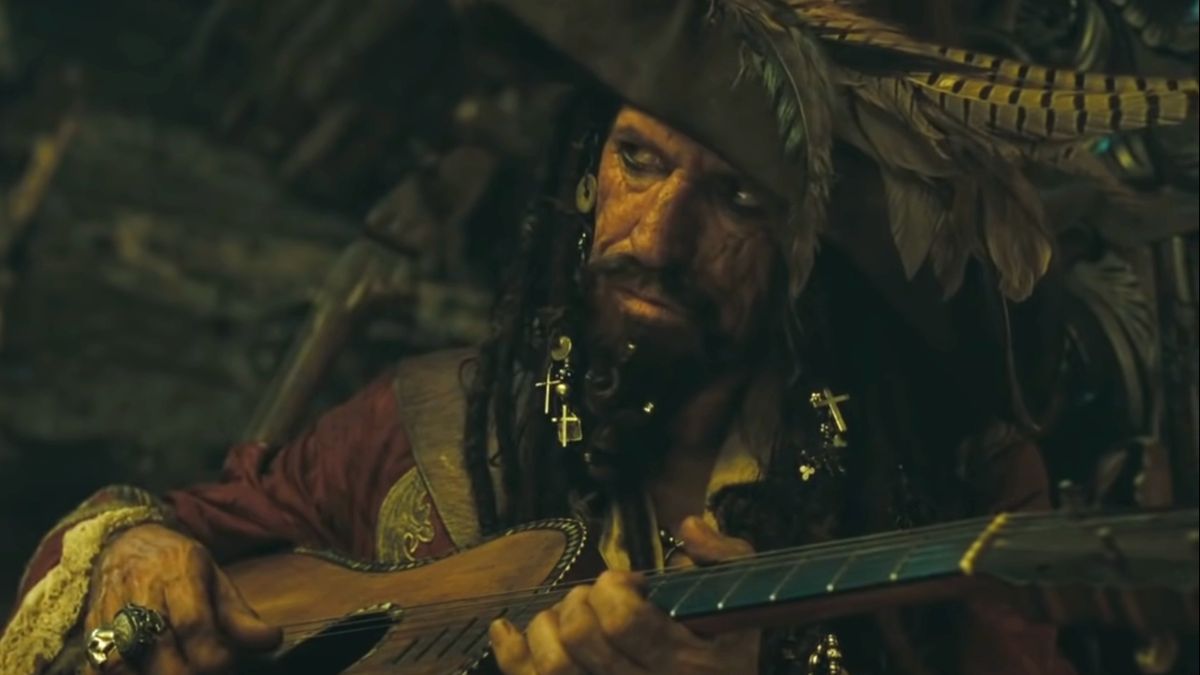 Keith Richards glances sideways while playing guitar dressed as a pirate in Pirates of the Caribbean: At World&#039;s End.