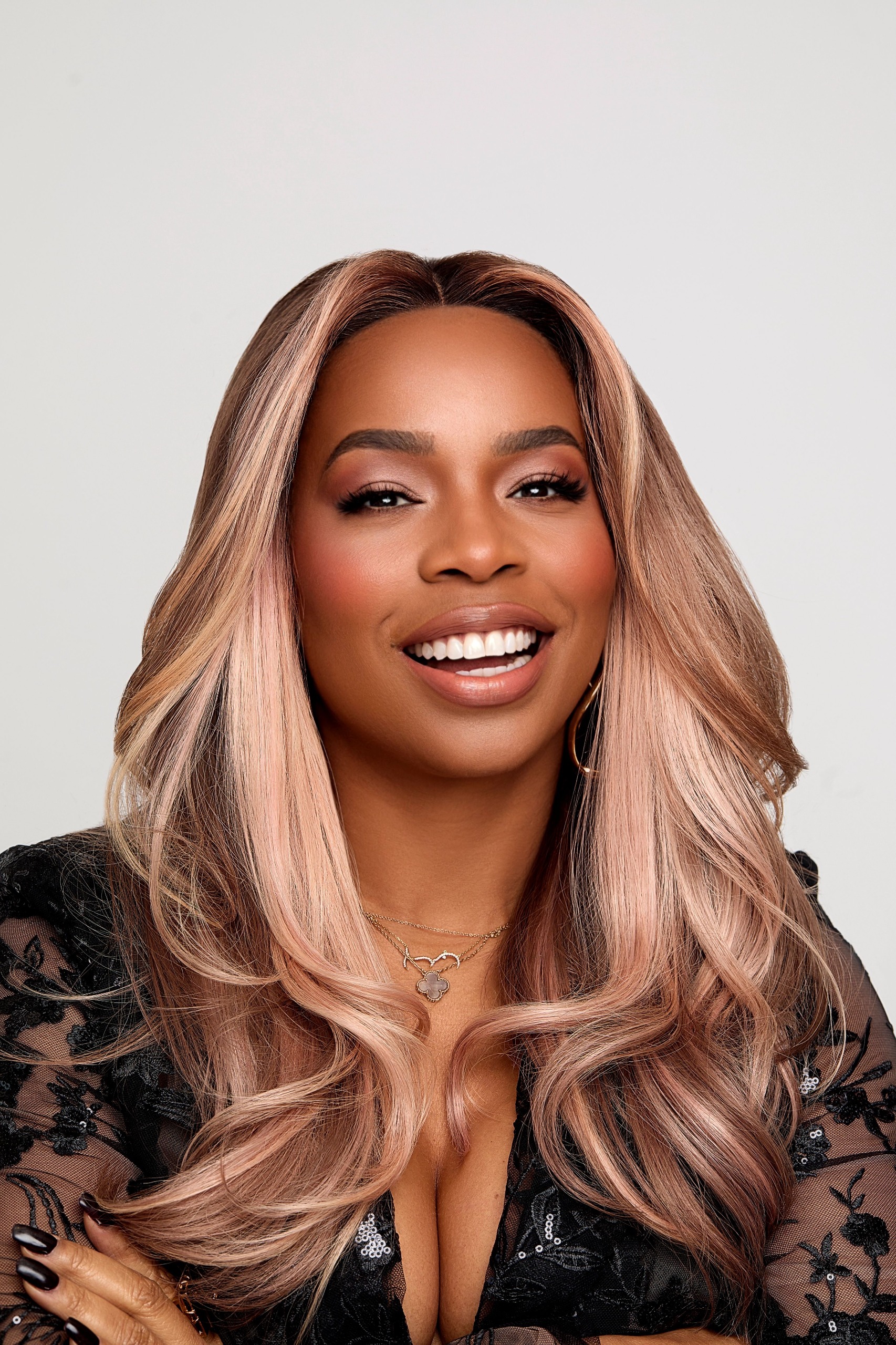 a black woman with long rose hair in a black lace top