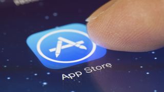 finger about to touch Apple App Store icon on iPhone