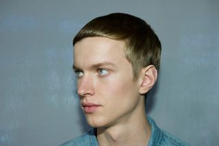 male model head shot looking to left side with smoothed over hair