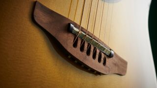 Close up of the bridge on an Ovation acoustic guitar