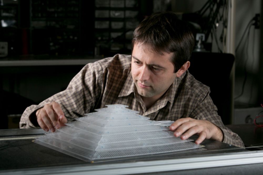 Bogdan Popa, a research scientist in electrical and computer engineering, shows off the 3D acoustic cloak he helped design and build as a member of Steven Cummer’s laboratory.