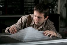 Bogdan Popa, a research scientist in electrical and computer engineering, shows off the 3D acoustic cloak he helped design and build as a member of Steven Cummer&rsquo;s laboratory.