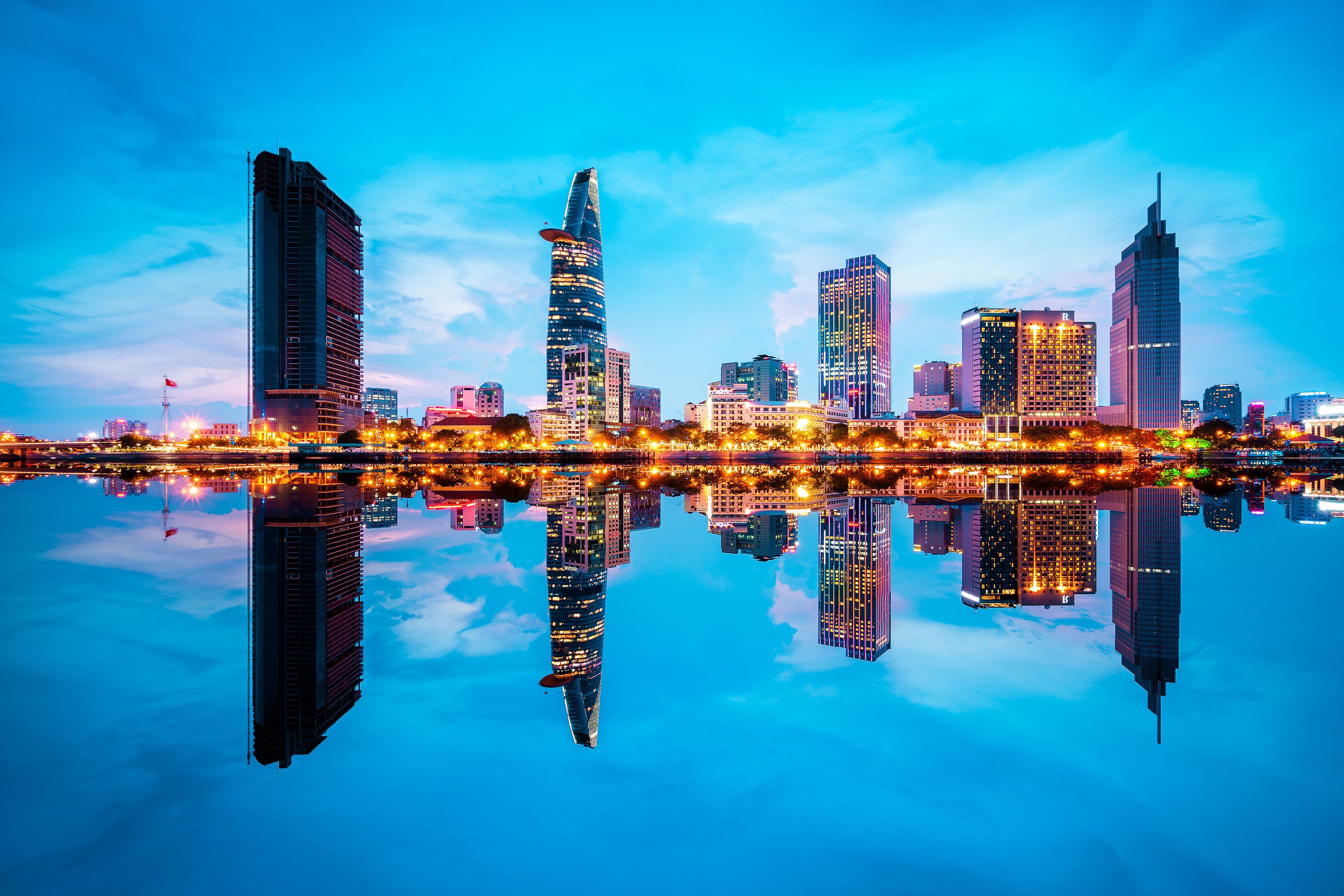 Reflection of Ho Chi Min cityscape in the Saigon river at twilight.