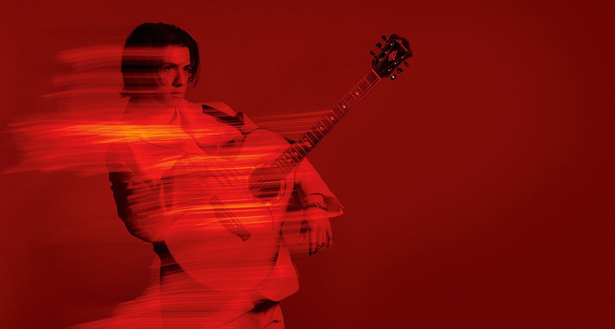 A deep red portrait of Marcin holding his Ibanez acoustic 