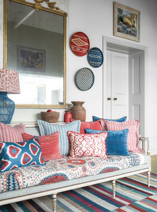 White entryway with bench and colorful cushions