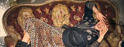 A woman in a leopard print Monsoon skirt and blue blouse, lying down on a sofa.