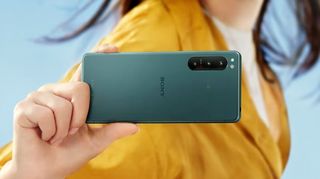 A Sony Xperia 5 IV in someone's hand, in green