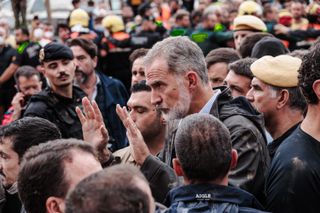 King Felipe of Spain holding his hands up in a crowd of people