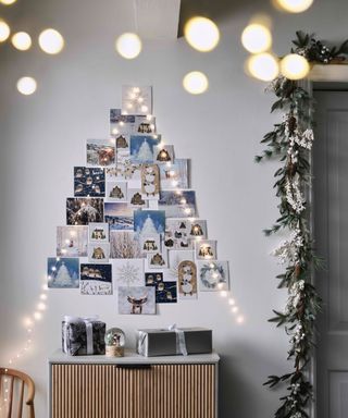 christmas cards on a wall with fairy lights in a tree shape by John Lewis and Partners