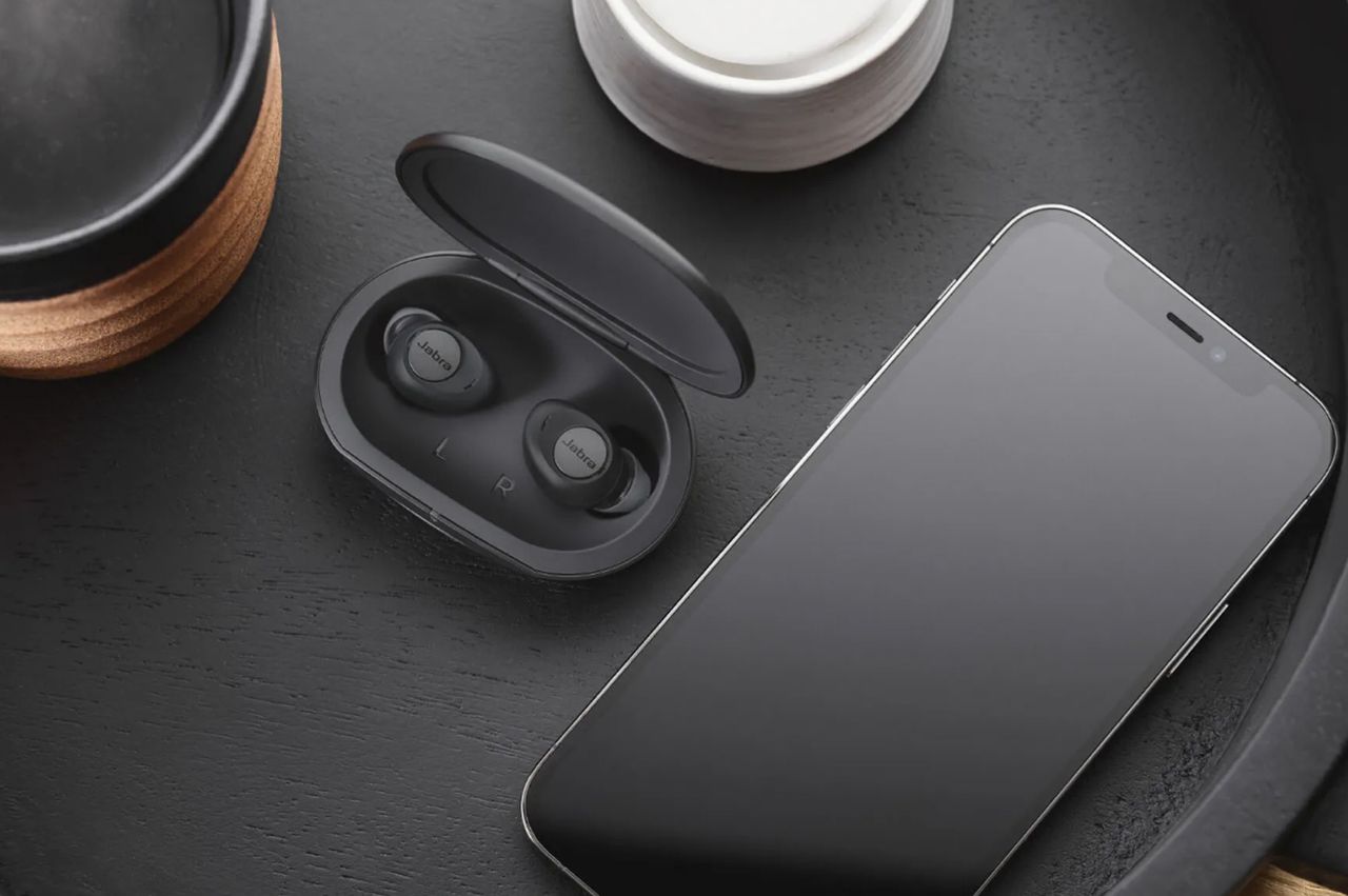 Jabra Enhance Plus earbuds next to a smartphone