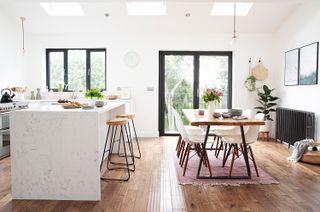 Charlotte Asquith's open-plan kitchen diner – with dining table and island and wooden flooring
