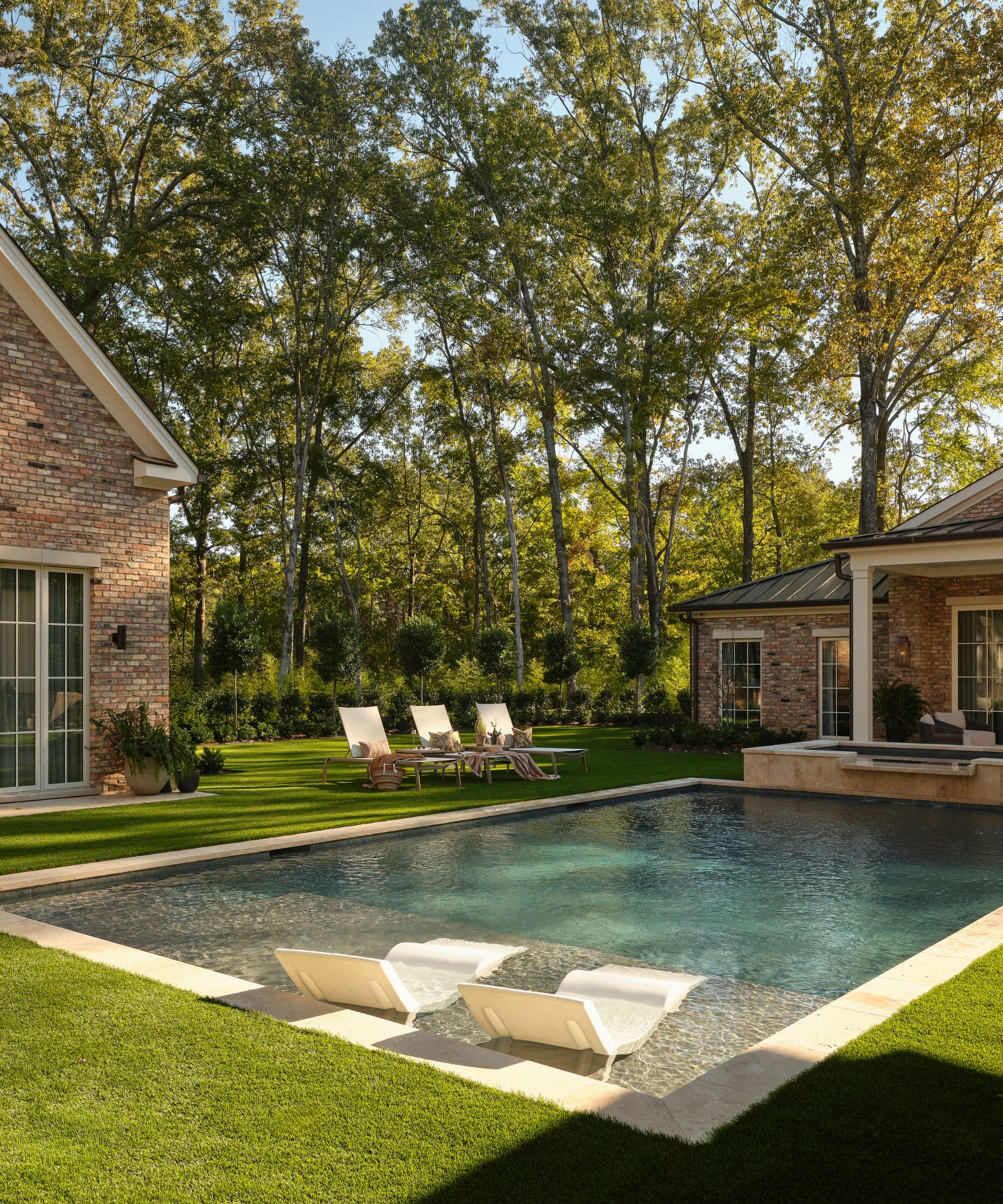 a leafy garden in Mississippi with a contemporary pool and a Georgian style pool house