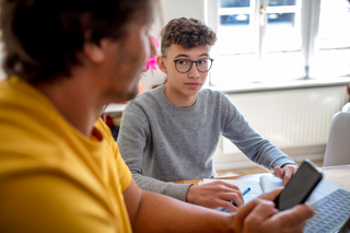 boy and dad looking at how to donate laptops for homeschooling