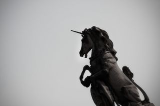 A black and white photo of a unicorn statue 
