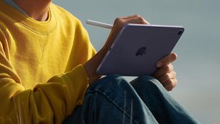 A man draws on the iPad mini outdoors.